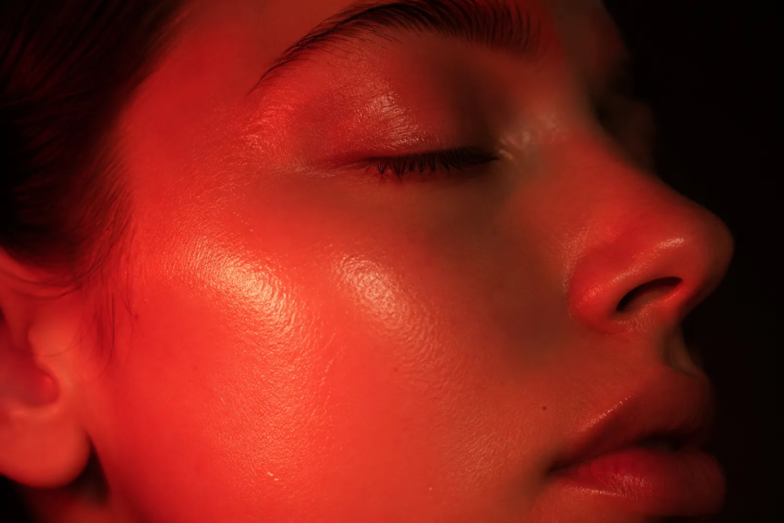 Close-up of glowing healthy skin under red light therapy