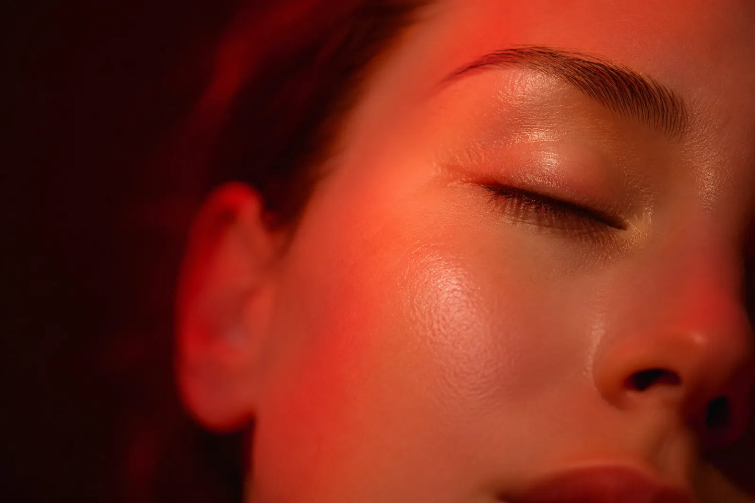 Close-up of clear, calm skin under red light therapy