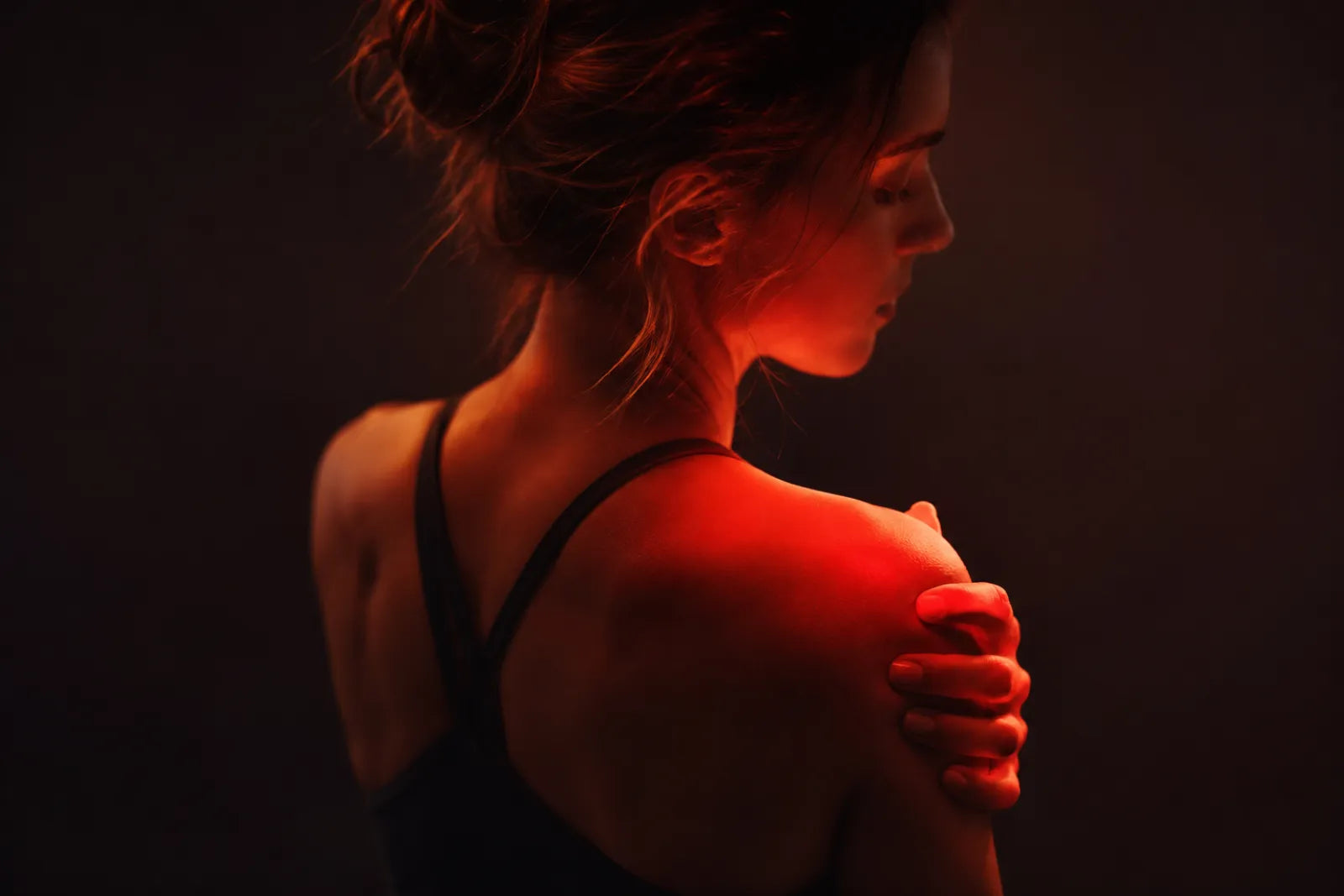 Warm red light glow over the shoulder, red light therapy for inflammation