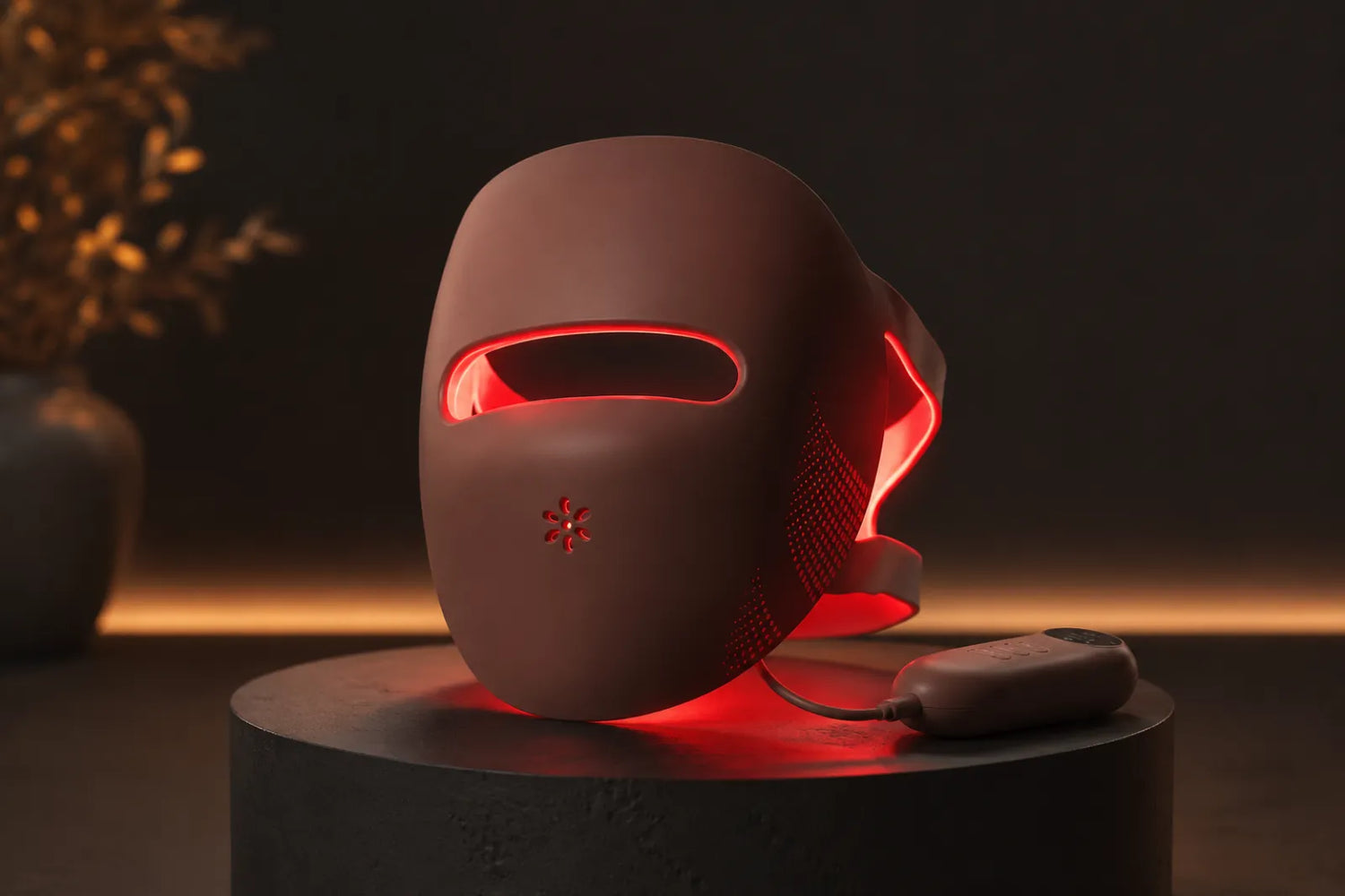 Premium Lumovex red light therapy LED face mask glowing on a dark pedestal
