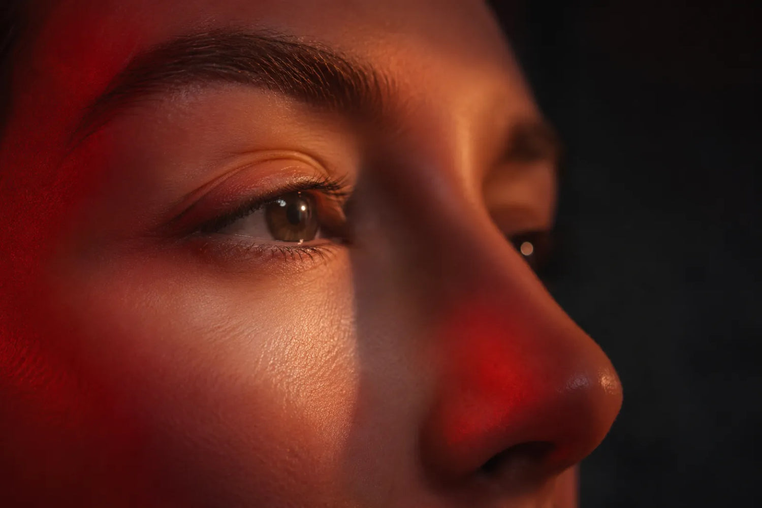Close-up of the under-eye area in gentle red light therapy