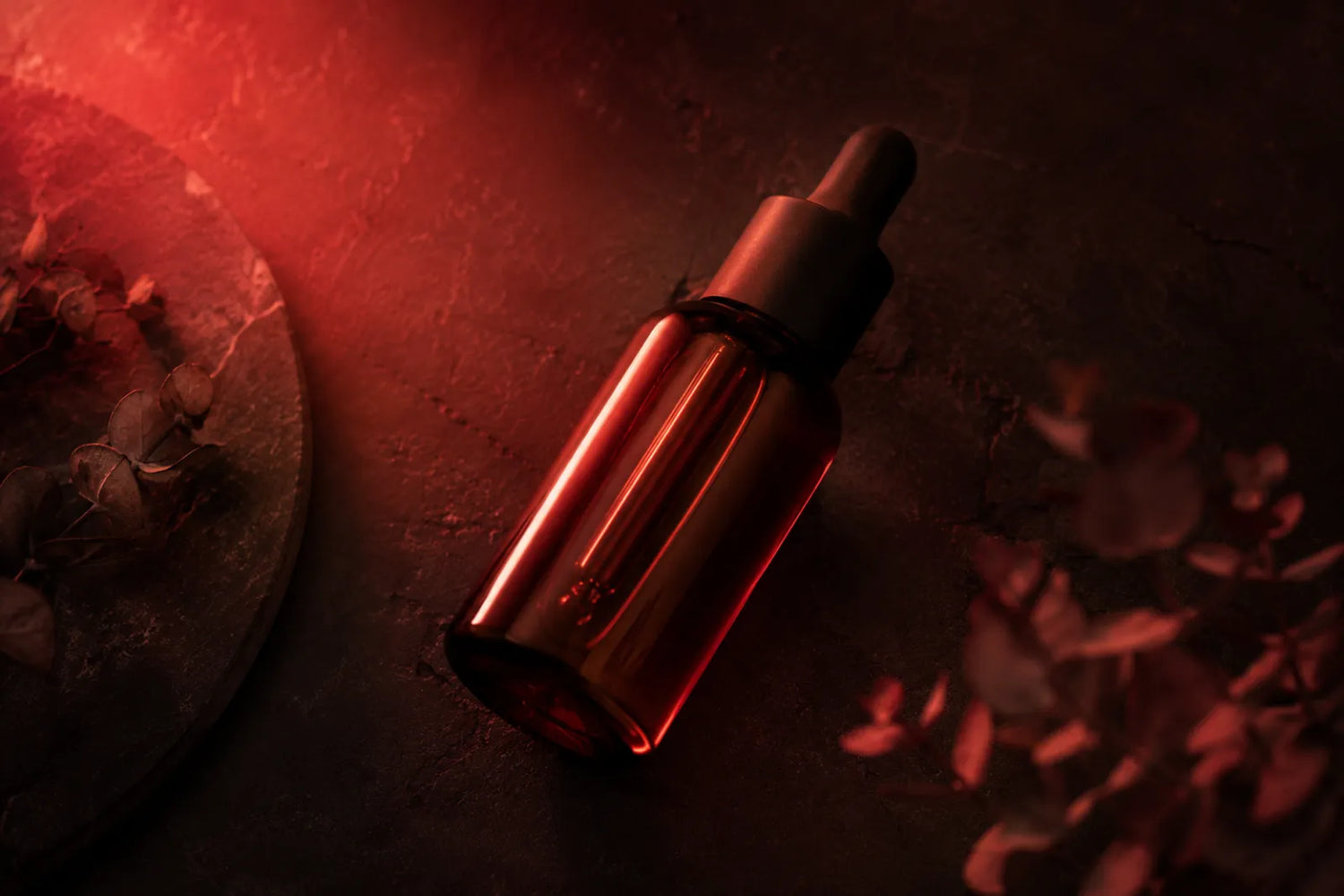 Retinol serum dropper under warm red light, red light therapy and retinol